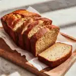 Gluten Dairy Free Banana Bread Recipe – Easy, Moist, Naturally Sweet 3 Sliced gluten dairy free banana bread on wooden board in modern kitchen